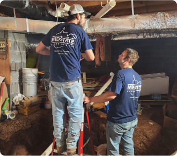 two employees working on basement plumbing